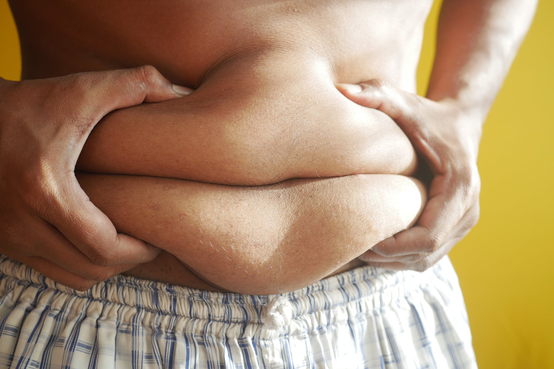 a person holding on to belly fat